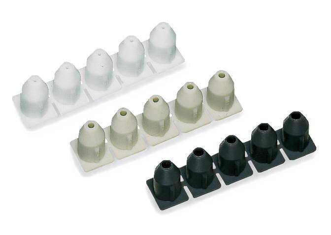 Three rows of plastic wall plugs in white, beige, and black, with four in each row, placed on a white surface.