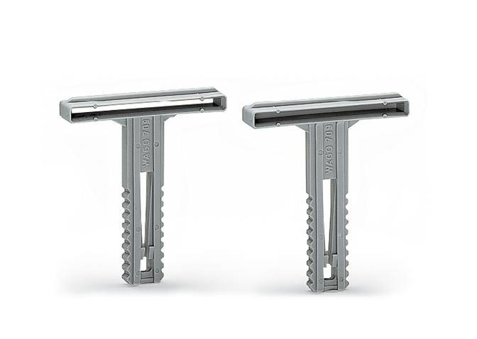 Two grey plastic wall plugs side by side, each with a wide head and toothed shank, standing upright against a white background.