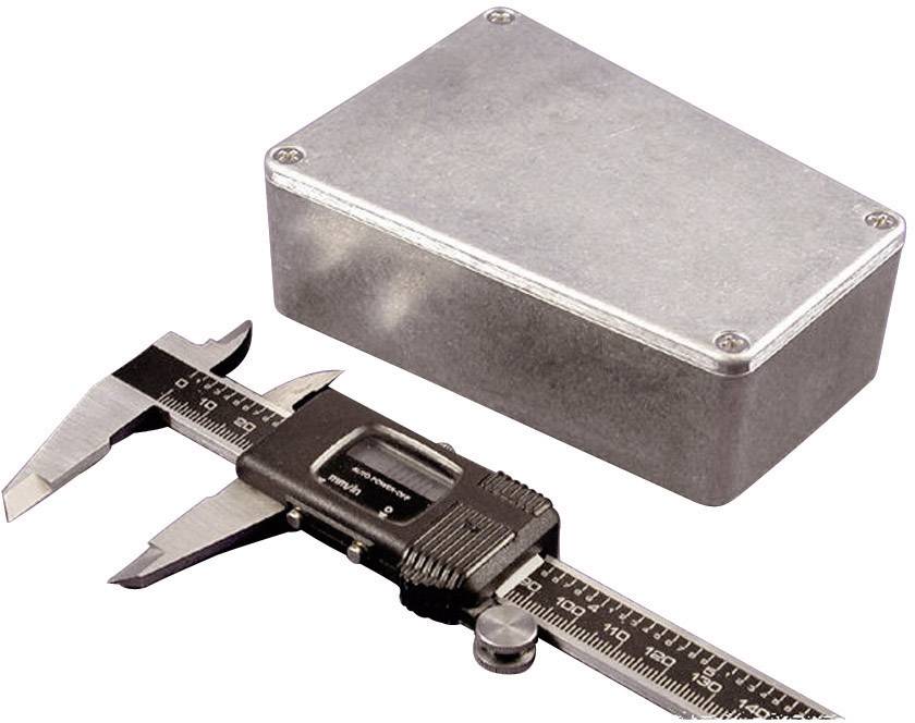 A silver-coloured metal box lies next to a calliper, which is used for measuring length.