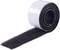 A roll of black hook-and-loop fastener tape lies on a white surface, partially unrolled.