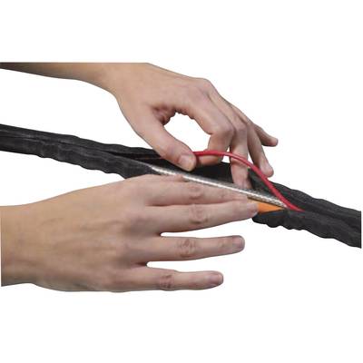 Two hands are wrapping a red cable into a black protective sleeve with a zip.