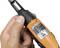 A hand is holding an orange and black tool with a label displaying technical specifications and the brand 'Thomas & Betts'.