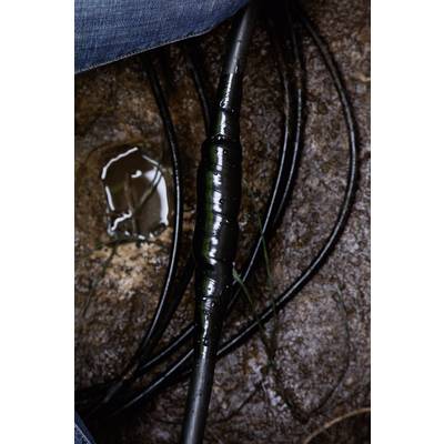 A black cable wrapped with insulating tape lies on wet ground. Water droplets can be seen on the tape, surrounded by earth.
