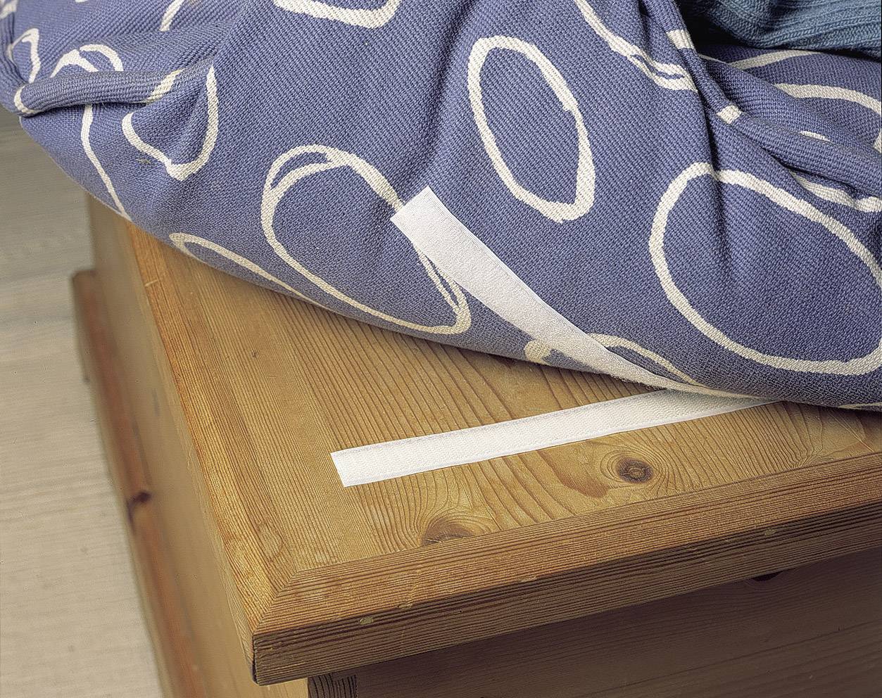 A table brushes against the bedcover, which is wrapped with a white ribbon to retain warmth.