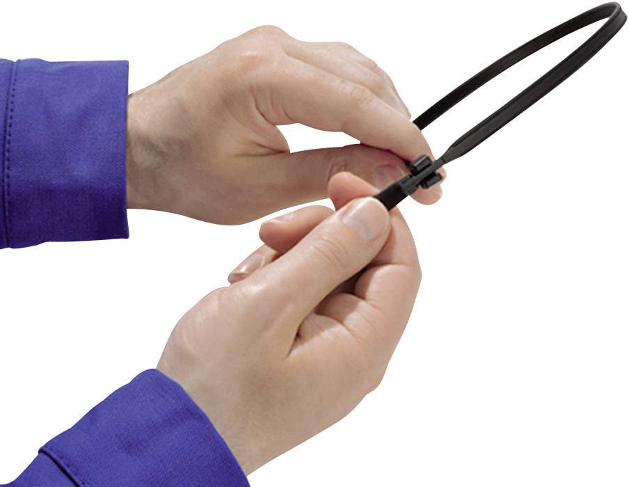 Two hands in blue clothing hold and fasten a black cable tie.