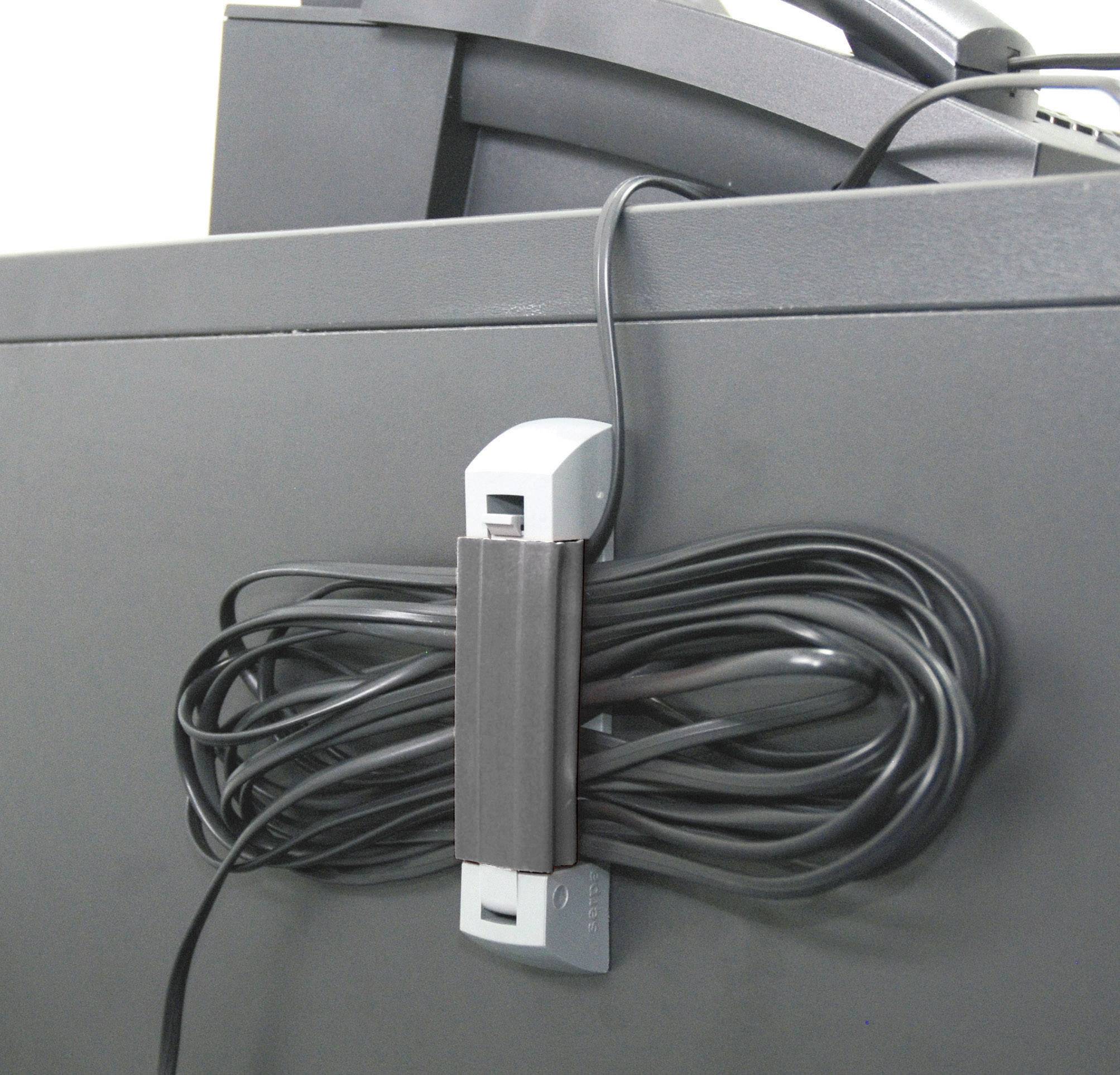 A black cable is neatly secured with a cable tie to a black desk to prevent cable clutter.