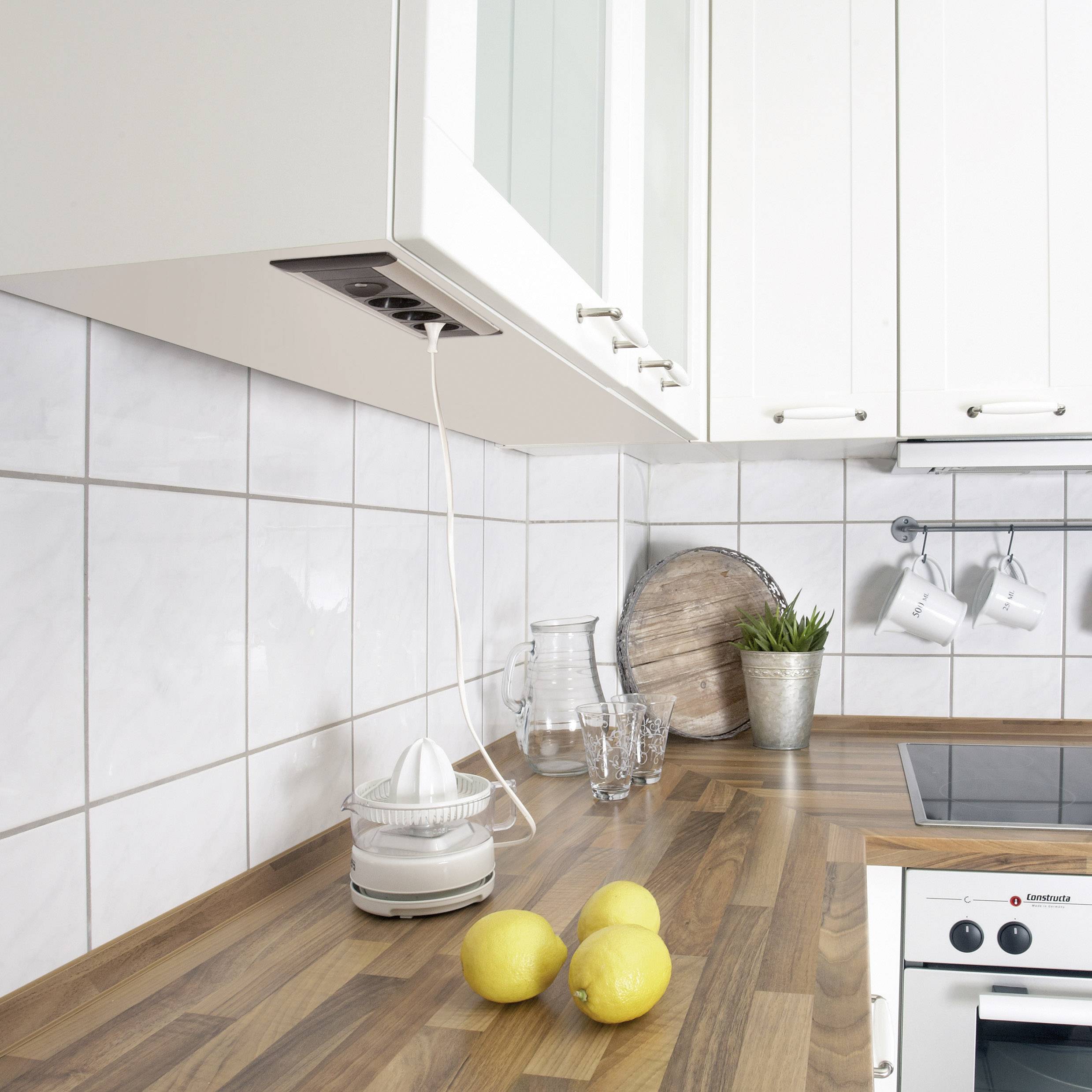 Modern kitchen with wooden worktop, tiled splashback, three lemons, glasses, pot and built-in cooker.