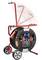 A red cable drum stand with multiple sockets, fitted with an extendable handle and movable wheels for easy transportation.