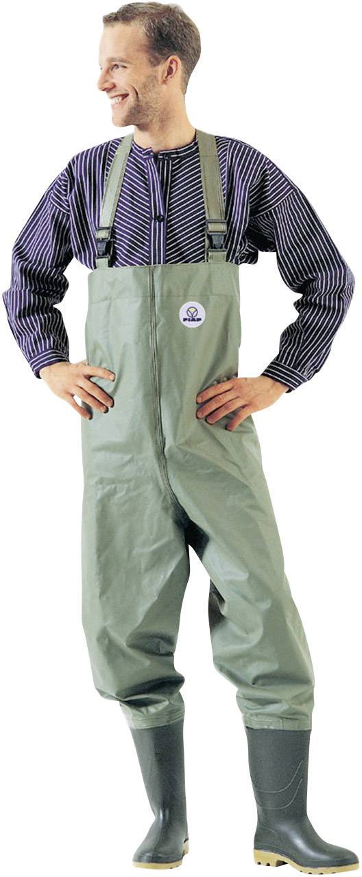 A smiling man wearing green waders and a striped jacket stands with his hands on his hips, gazing into the distance.