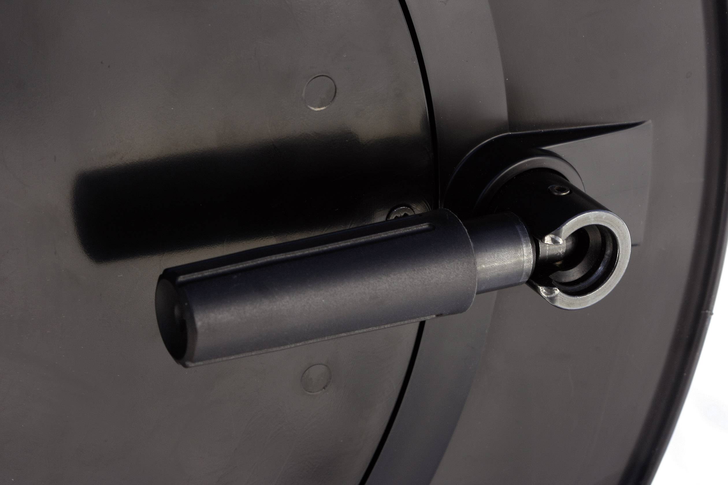 Close-up of a black handle on a circular device, likely part of a machine or tool.