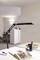 A modern office with minimalist furnishings: desk lamp, office chair, and shelving. An open book lies on the desk.