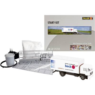 Model railway starter set with lorry model, decorative pieces and accessories. Packaging depicts landscape and lorry on road.