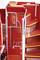 'The interior of a red bus, showing steps leading up to an upper level, surrounded by metal handrails.'