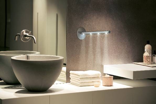 Modern bathroom with a washbasin, towels, and soap dispenser on a white shelf, illuminated by LED lighting.