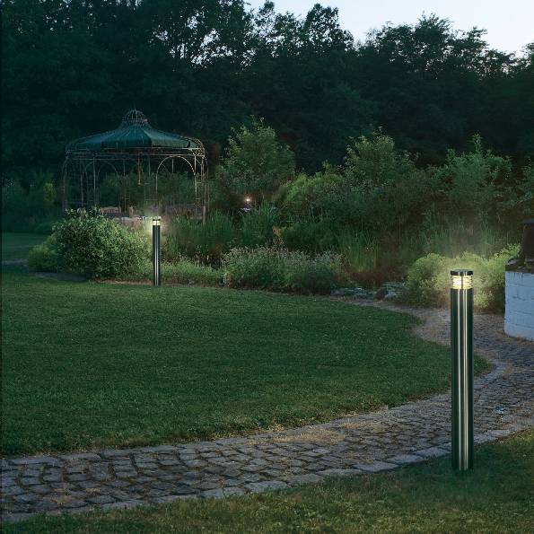A garden at dusk with illuminated pathways, a circular summerhouse in the background, and lush vegetation.