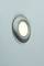 A round, metallic camera lens aperture on a black surface against a light blue background.