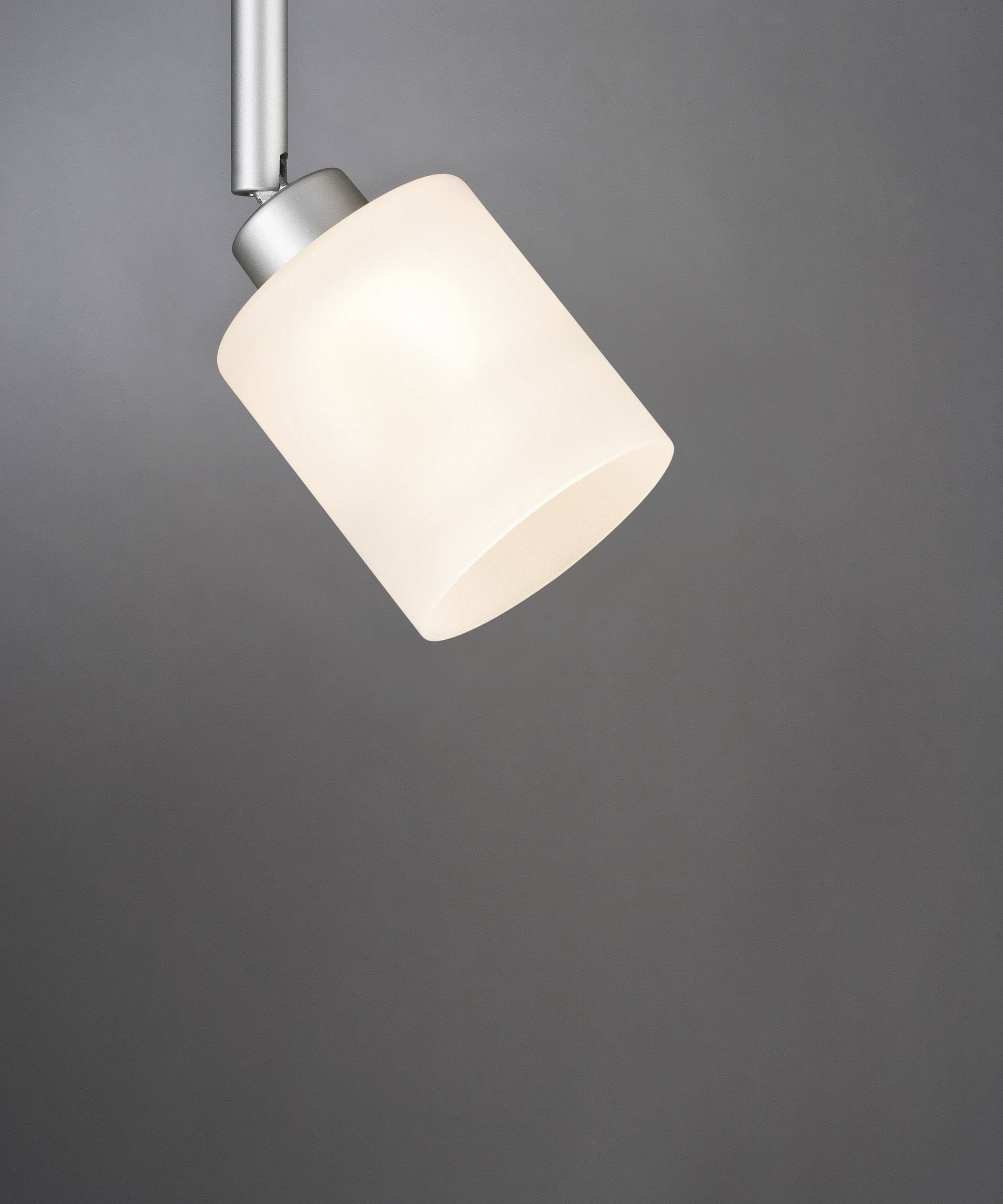 A single white pendant light with a cylindrical shade illuminates against a grey background.