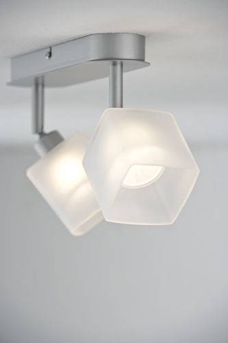 Ceiling light with two hexagonal, white lamp shades that emit bright light. They are suspended from silver brackets.