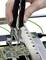 A hand holds tweezers and is working on a circuit board with delicate electrical components.