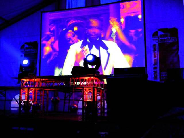 A canvas with a blurred image of a person in a white suit. Colourful stage lights in the foreground.