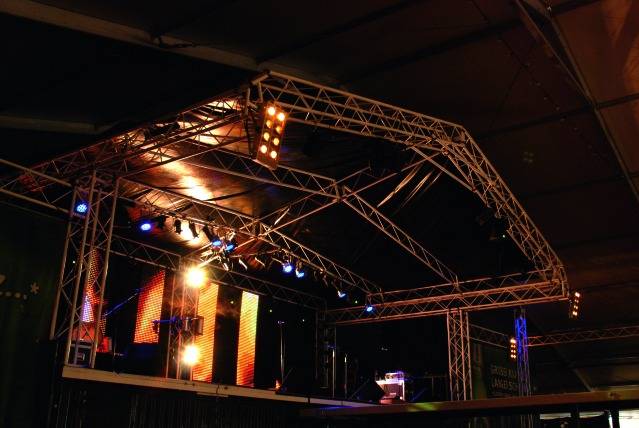 Stage at night with colourful lighting and speakers, ready for a concert or an event.
