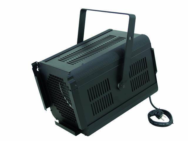 A black stage flood light with a carrying handle and power plug is lying on a white surface. Suitable for lighting effects.