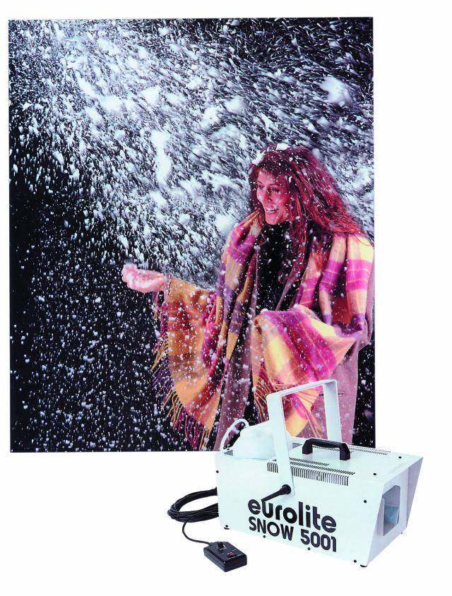 A woman smiles beneath artificial snow. In the foreground, a 'Eurolite Snow 5001' snow machine is visible.