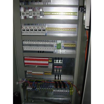 An open electrical cabinet with various electrical components and wires used for control and distribution purposes.