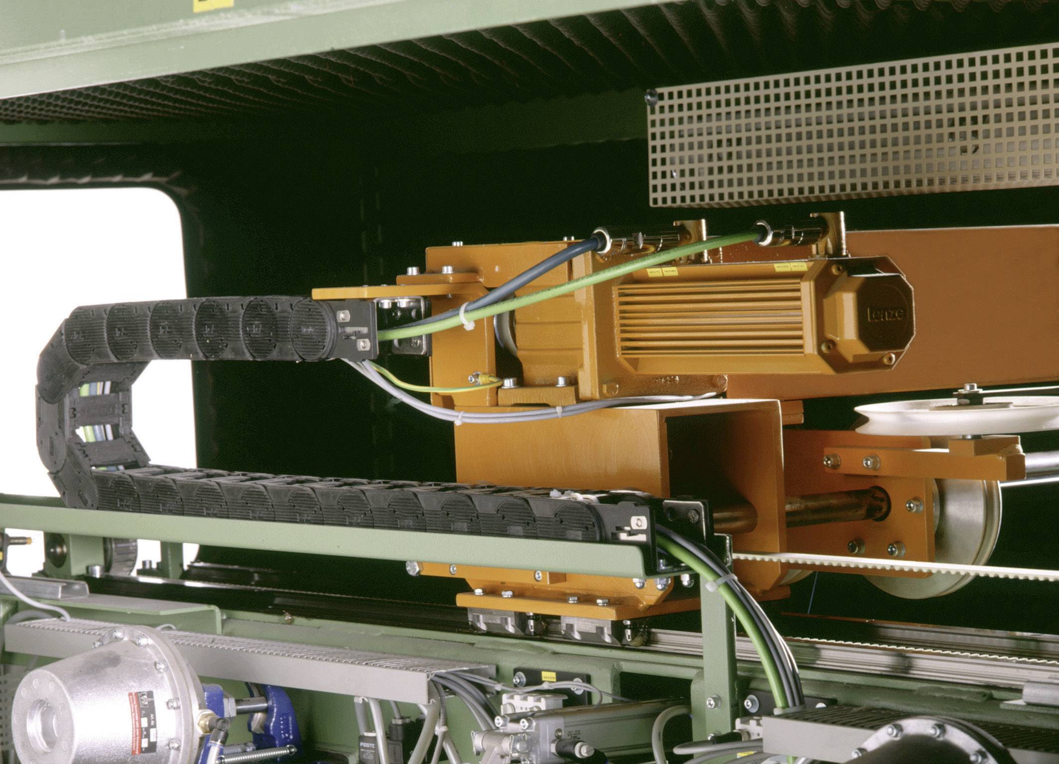 Industrial machine with orange components and cables used for automating a production process.