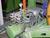 Industrial installation with a green hydraulic pump, multiple hoses and pressure gauge.