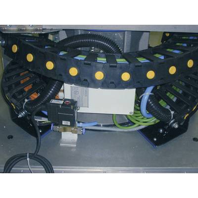 A mechanical component with cables and hoses. Black carriers with yellow dots are visible at the top. An electronic module is located underneath.