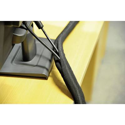 Cable management beneath a desk, with cables neatly bundled in a black cable trunking.
