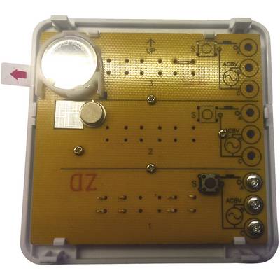 An electronic device with multiple circuit boards and buttons. A small battery is located in the top left corner.