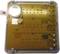 An electronic device with multiple circuit boards and buttons. A small battery is located in the top left corner.