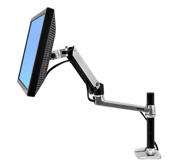 A flat-screen monitor is mounted on an adjustable, silver monitor arm attached to a desk.
