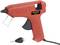 A red hot glue gun with an interchangeable nozzle, suitable for DIY projects and craft work, is lying on a white background.