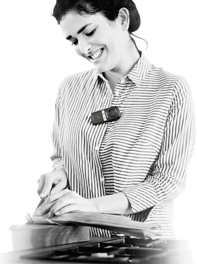 A person is chopping vegetables on a chopping board and is wearing a small electronic device on their shirt.