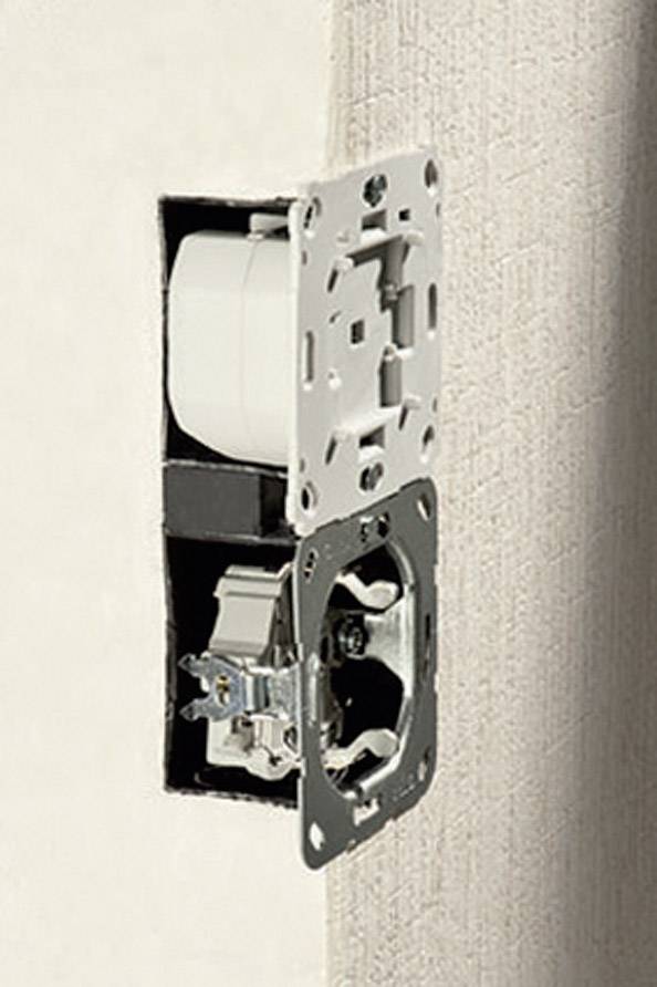 A partially mounted socket on a wall, without a cover, reveals exposed electrical components.