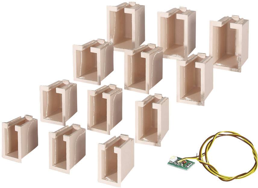 Twelve pink connectors in two rows next to a small electronic component with yellow cables.