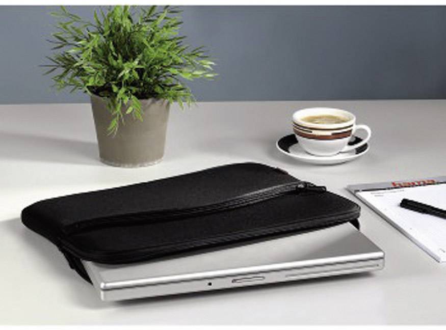 A laptop with a black case is lying on a table. Beside it are a cup of coffee, a notepad, and a green plant.