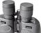 A black pair of binoculars in close-up. It shows adjustable eyepieces and rotatable controls for focus and zoom.