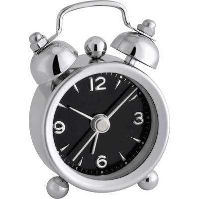 A silver alarm clock with a black dial shows the time as 10:09. The alarm clock has two bells on top and stands on two feet.