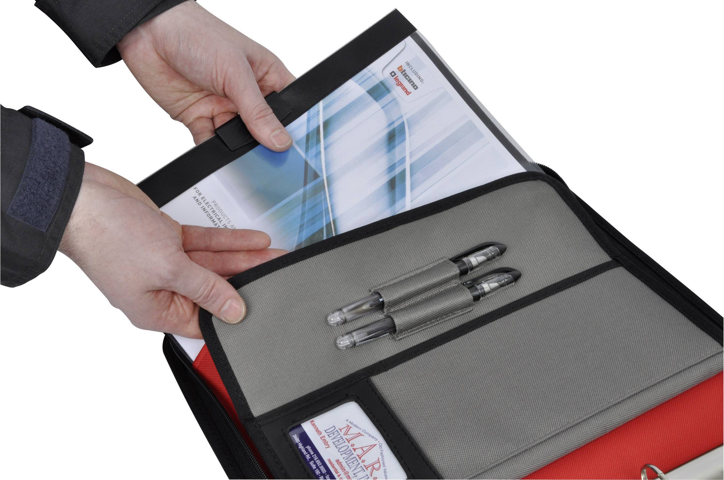 A person is placing a document into an open folder with a pen holder.
