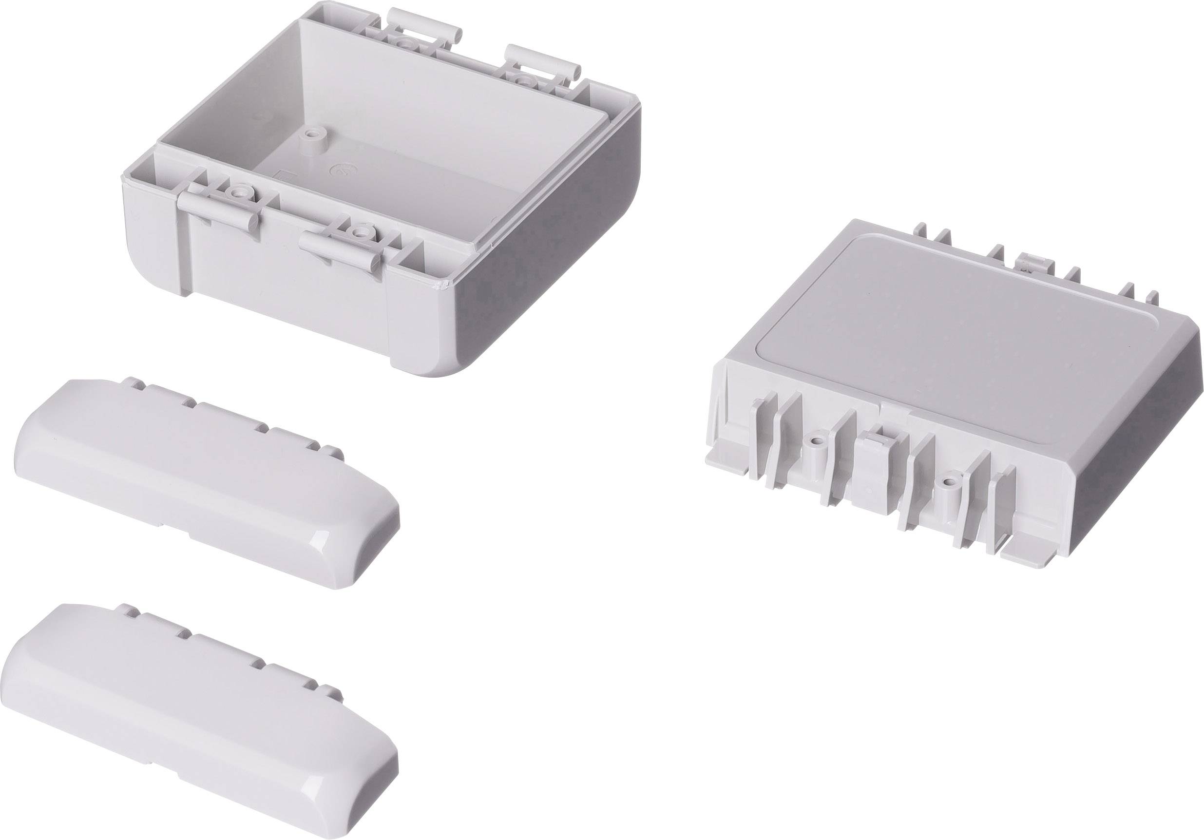 Four rectangular grey plastic components, a housing cover and three modular parts that fit together.