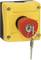 Yellow safety lock with a red rotary switch and a key inserted for emergency shutdown in industrial facilities.