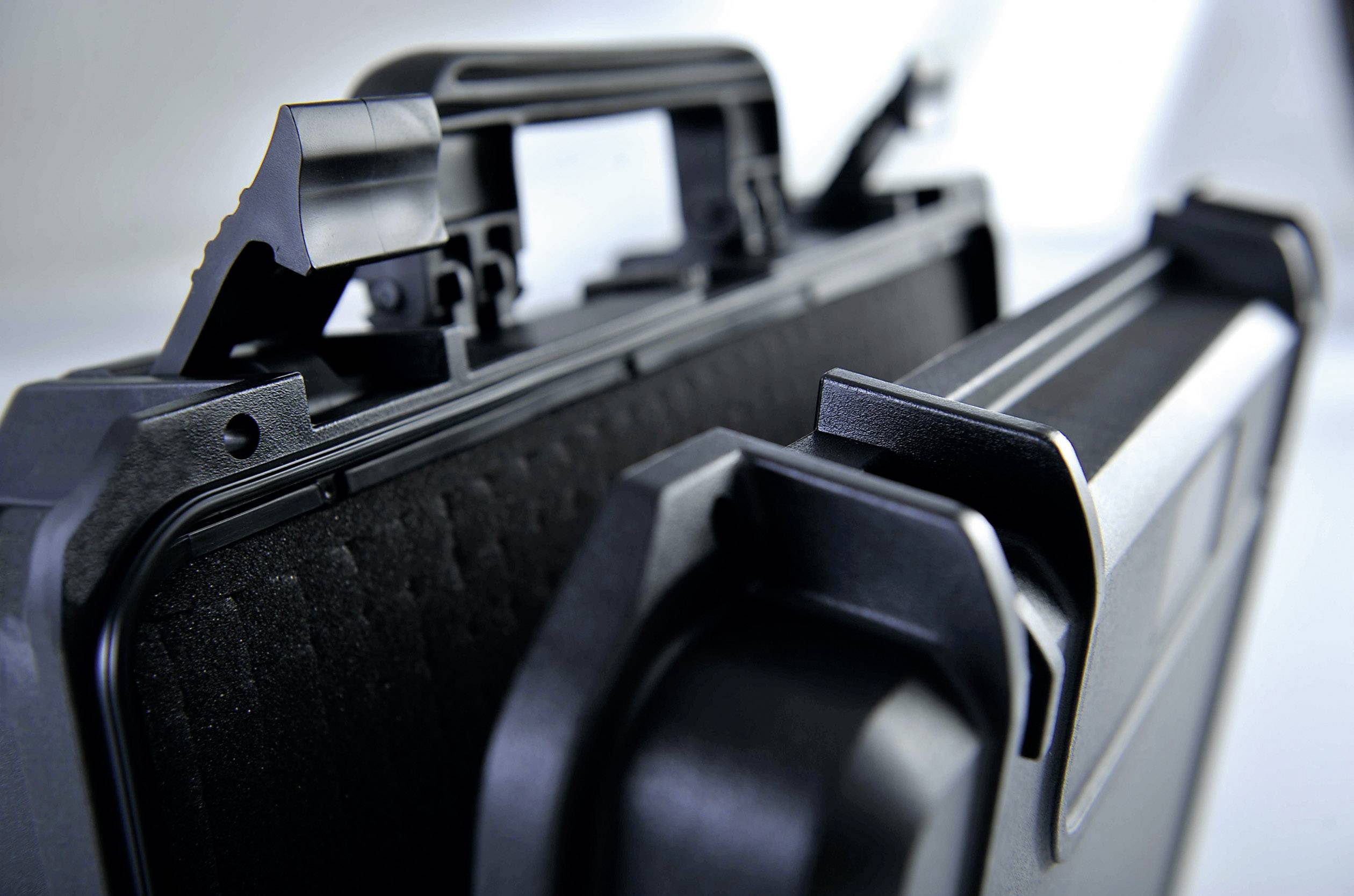 Black, open plastic transit case with foam lining, focus on the closure mechanism.