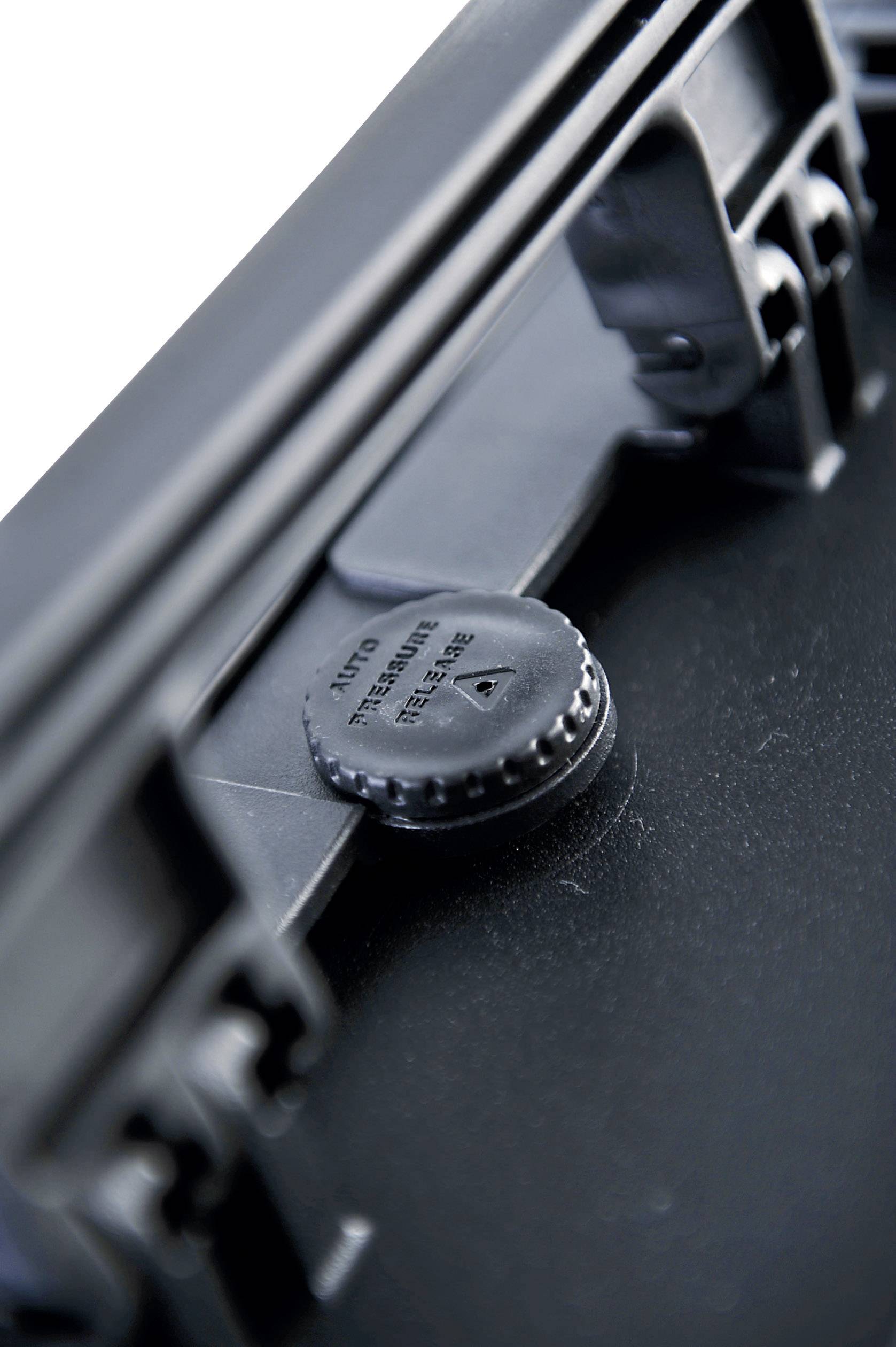 Close-up of a black fastener with a screw closure in a corner of a suitcase, with the text 'Turn Release' visible.