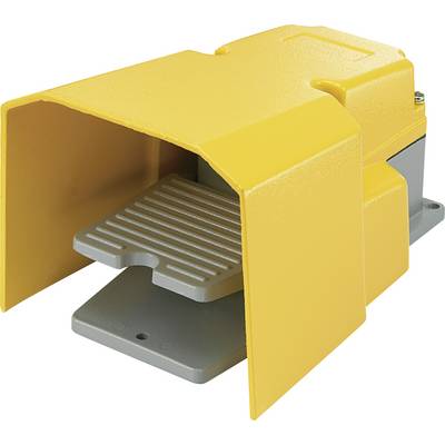 Metal foot pedal in yellow and grey, used for machine control. Protected from accidental activation by surrounding cover.