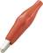 Red crocodile clip with insulated handle, commonly used in electrical applications for safely connecting wires or contacts.