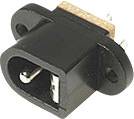 Black DC socket with two mounting holes and three electrical pins, suitable for mounting on a circuit board.